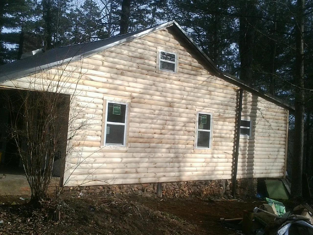 New log siding and dark metal roofing on a gable end in Manassas
