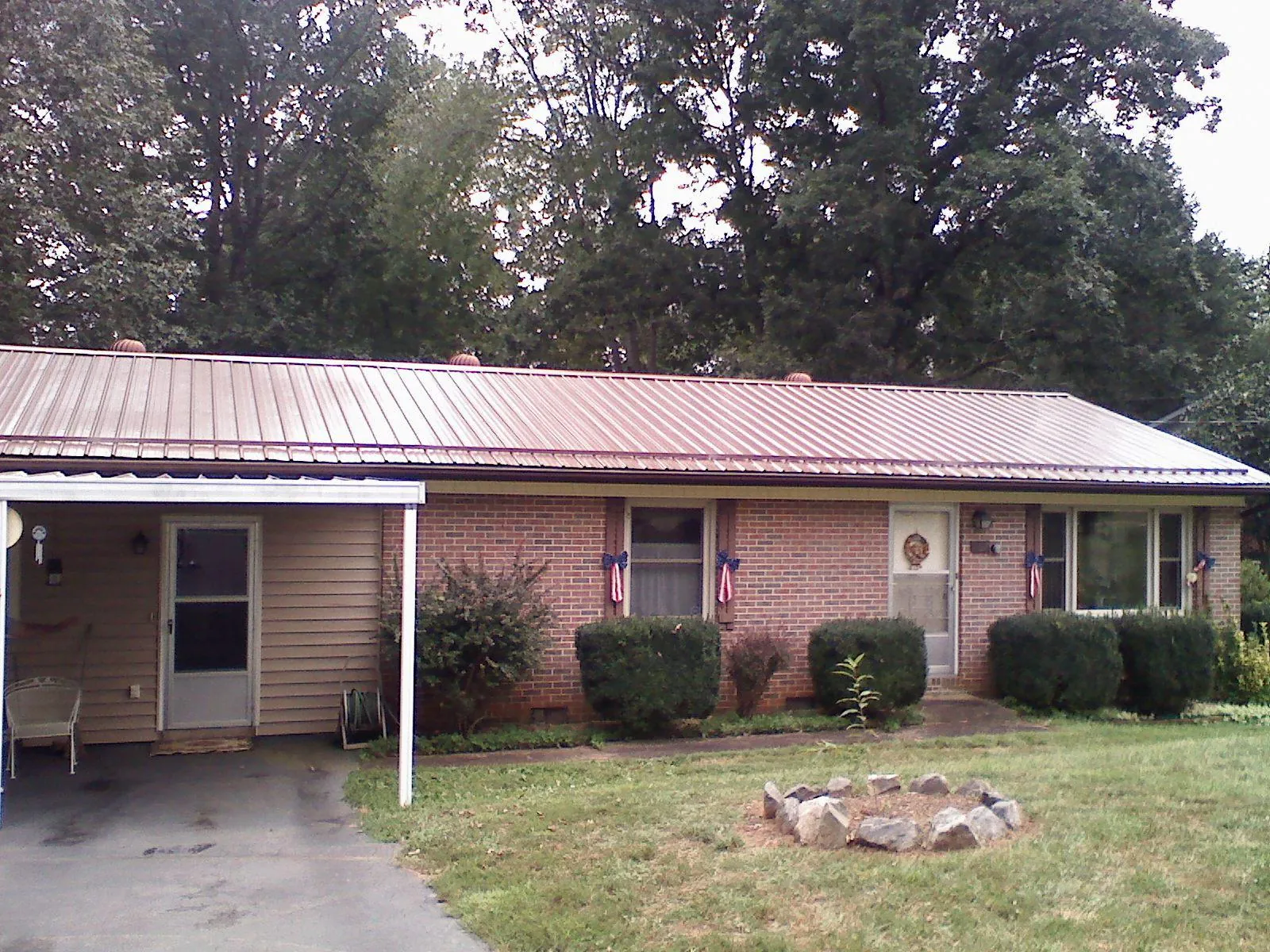 Bronze metal roof and carport on a brick ranch home — Roof Repair work by our crew in Manassas